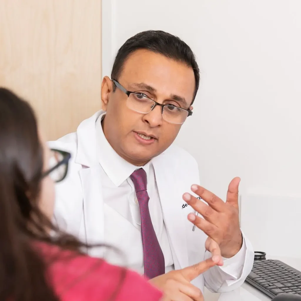 Dr. Pradeep S. Prasad consulting with a patient in his exam room at Retina Vision Consultants