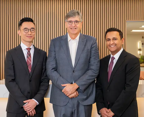 Drs. Kirk Hou, Steven Schwartz, and Pradeep Prasad, founding surgeons of Retina Vision Consultants, standing together in the office reception area
